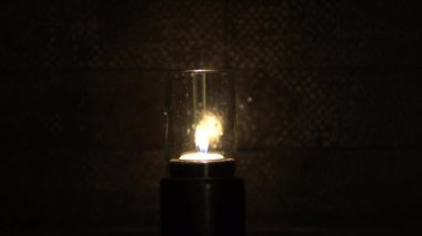 Gece karanlığında mum yanıp sönüyor. Banyoda yansıyor. Romantik, havalı bir hava.