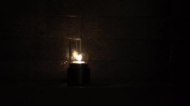 Gece karanlığında mum yanıp sönüyor. Banyoda yansıyor. Romantik, havalı bir hava.