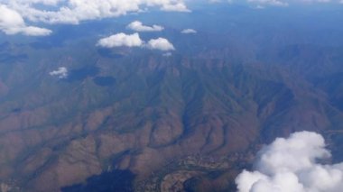 Plane aerial view of Thailand green tropical mountain forest with small rural town landscape