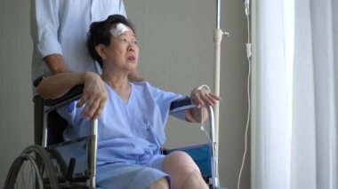 Hopeless injured wife on wheelchair in hospital very bad condition sad senior couple emotional support crying hugging