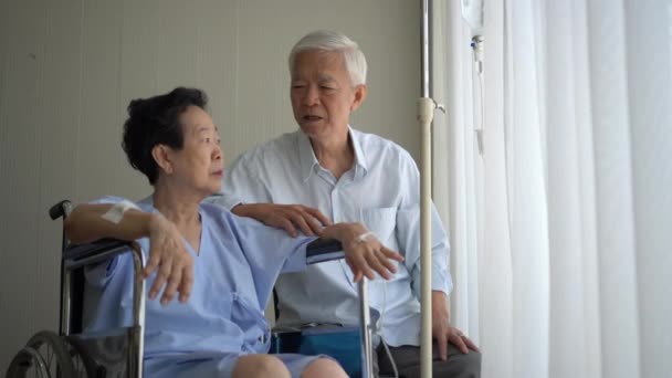 Asyalı Yaşlı Koca Tekerlekli Sandalyedeki Yaralı Eşiyle Konuşuyor — Stok video
