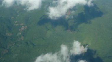 yeşil yemyeşil tropikal dağ alçak bulutlu yüzen hava manzaralı uçak penceresinden