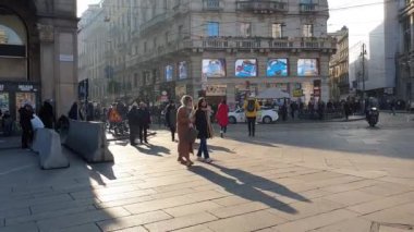 Milan, İtalya 17 Aralık 2022 Gucci binası, akşam güneşli. Alışveriş bölgesinde gezen insanlar moda şehri