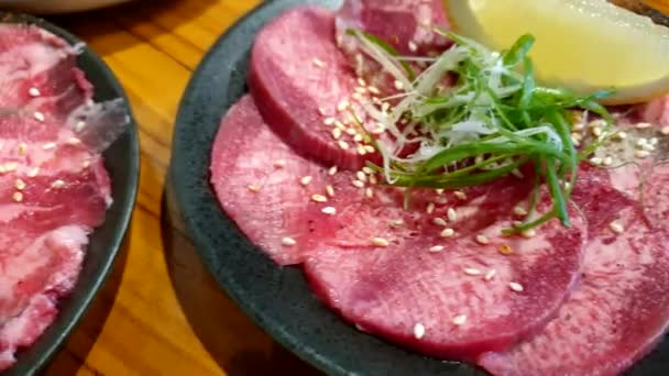 日本风格的龙涎香薄片牛肉舌根烤肉配柠檬绿色洋葱味道鲜美 — 图库视频影像