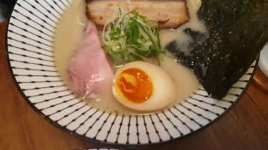Tonkotsu ve kara ramen, domuz kemiği çorbası ve baharatlı krema çorbası sıcak Japon erişte kasesi domuz yosunlu negi ve yumurta dilimli