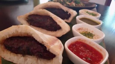 Pide ekmeğinde kıymalı kuzu kebabı. Tabulu salata ve kızarmış Arap yemeği.