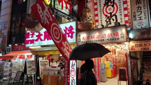 日本大阪 2023年5月6日 商店和餐馆区游客和当地居民在雨天的街灯下散步 照亮了市中心五彩斑斓的地标 — 图库视频影像