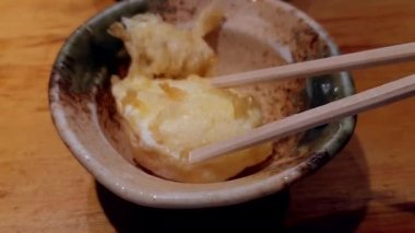 Yarı haşlanmış yumurta sarısı tempura sade Japon zen tarzı bol yağda kızartılmış yemek çubukları.