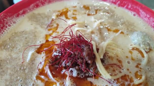 日本菜吃面辛辣的菜色棕褐色拉面丹丹浓汤上涂红辣椒油 — 图库视频影像