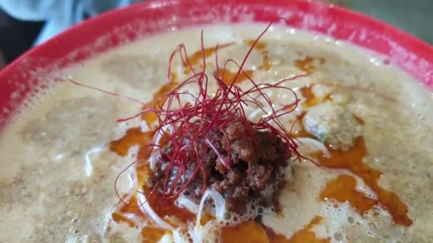 日本食ラーメン辛い料理タンタンラーメン天安門の太めのスープに赤唐辛子油をかけて食べる — ストック動画