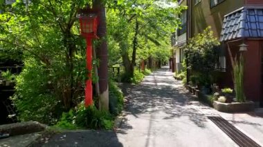 Kinosaki Onsen, Japonya 16 Mayıs 2023 Yerel sahne kırmızı lamba yürüyüş yolu ve sıcak kaynak yeşil ağaçlar etrafında ev