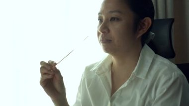 Asyalı kadın burun testi yapıyor. Kovid 19 antijen test kiti.