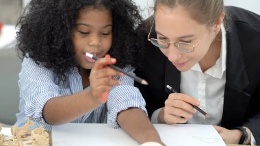 Çeşitli okullarda yaratıcı sınıf Kafkas öğretmeni ve Afrikalı çocuk eleştirel düşünmeyi öğrenirken eğleniyorlar küresel vatandaşlık eğitimi kavramsal