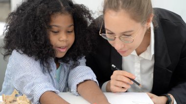 Çeşitli okullarda yaratıcı sınıf Kafkas öğretmeni ve Afrikalı çocuk eleştirel düşünmeyi öğrenirken eğleniyorlar küresel vatandaşlık eğitimi kavramsal