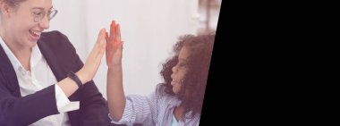 Afrikalı Amerikalı siyahi kız, Kafkas öğretmeniyle uluslararası çeşitlilik okulu ortamında gülümseyerek eğleniyor.