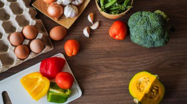 Flay yemek pişirirken sebze brokoli yumurta biber bezelye sarımsak arkaplanı ahşap dokusu metin kopyalama alanı