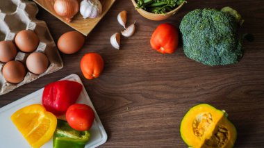 Flay yemek pişirirken sebze brokoli yumurta biber bezelye sarımsak arkaplanı ahşap dokusu metin kopyalama alanı