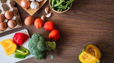 Flay yemek pişirirken sebze brokoli yumurta biber bezelye sarımsak arkaplanı ahşap dokusu metin kopyalama alanı