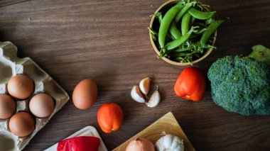 Flay yemek pişirirken sebze brokoli yumurta biber bezelye sarımsak arkaplanı ahşap dokusu metin kopyalama alanı