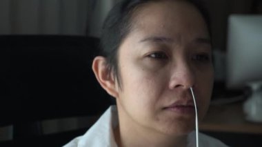 Asian adult woman tear crying reaction from covid 19 nasal kit test