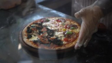 İtalyan yemek şefi tekerlek bıçağı kullan. Pizzacıda iki pizza kes...