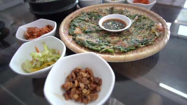韓国のオックスボーンスープを食べるハンドフル韓国の伝統的なパンケーキとサイドディッシュモーションショット4K — ストック動画