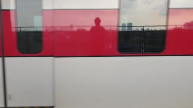 Kırmızı beyaz Japon treni platforma yaklaşıyor.