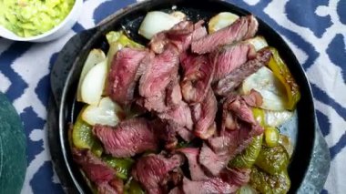 Meksika usulü sığır fajita demir tabak guacamole 4k ile üst görünüm cızırdıyor