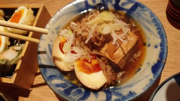 Käsisyömäpuikot Syöminen Pieni Lisuke Japanilainen Izakaya Ruoka Naudanliha Muhennos Tofu — kuvapankkivideo