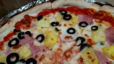 Ananaslı ve siyah zeytinli Hawaii pizzası. Ev yapımı İtalyan yemeği. 4K.