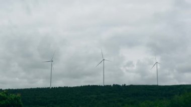 Yel değirmeni rüzgar enerjisi çiftliğinin zaman aşımı bulutlu gökyüzünde iyi çalışıyor sürdürülebilir enerji çözümünde