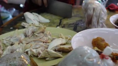 Tayland market tezgahında haşlanmış tavuk satarken pirinçle birlikte Hainan usulü tavuk kesmeye hazır olun.