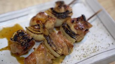 Yakiroti izakaya tavuk şişi ve soğan teriyaki sosu Japon yemeği tabakta servis ediliyor.