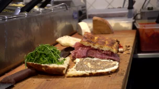 フィレンツェのパンサラミスライス肉野菜とソースでイタリアンサンドイッチを調理 — ストック動画