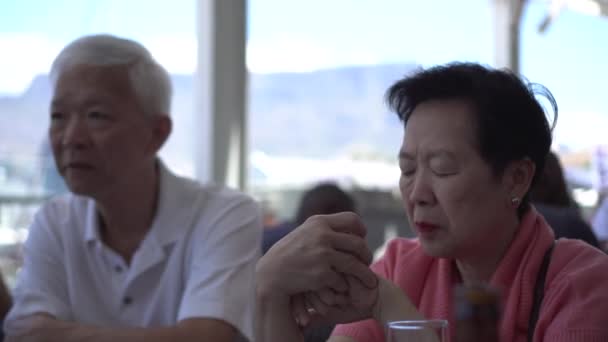 アジアのシニアカップルはケープタウン南アフリカのハーバーテラス旅行で外食する — ストック動画