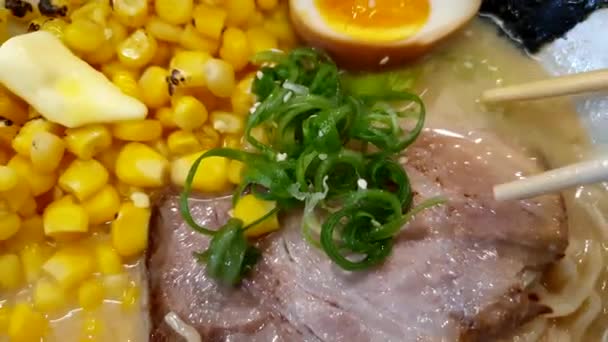 北海道トウモロコシバターラーメン ホットラーメンポークスライス 箸を食べる トップビュー4K — ストック動画