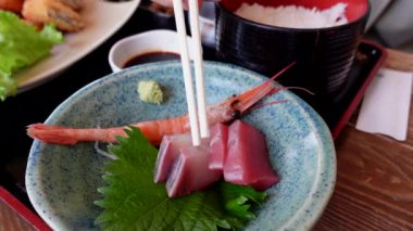 Japon taze deniz ürünleri yiyen yemek çubukları Japonya 'daki yerel sahil restoranında sashimi ile pirinç ve balık pişirdiler.