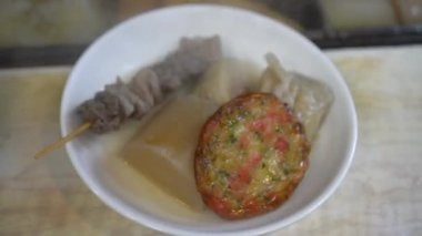 Oden restoranı soğuk sonbahar kış kış 4k için haşlanmış sıcak çorba ve balık köftesi servis ediyor.