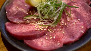 Bir dilim sığır eti dili gyutan limonu Japon yakiniku bbq yemeği.