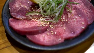 Bir dilim sığır eti dili gyutan limonu Japon yakiniku bbq yemeği.