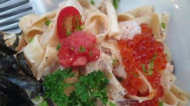 Somon yumurtalı makarna ve deniz yosunu ve kremalı morina balığı yumurtası Japon İtalyan yemeği 4K.