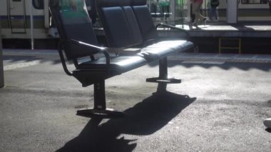 Japonya 'da güneş ışığı ve gölgesi 4k olan tren peronunda oturma koltuğu.