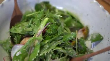 Kürekler yeşil salatayı balkabağıyla karıştırıyor domates pancarı ve midye sağlıklı yiyecekler.