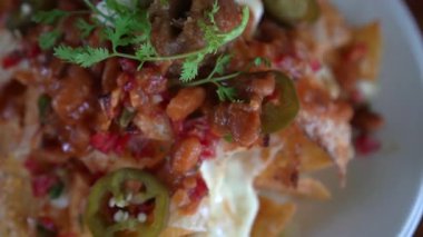 Meksika yemeğinin üstüne peynirli ve acılı nacho taco. 4K.