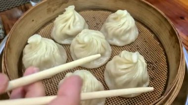 Elleri çubuklu Xiaolongbao çorbası yiyen Çin yemeği.