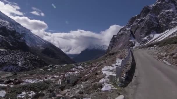 山の丘の道に向かって雪の風景を通って車を運転するフロント ドライビング — ストック動画