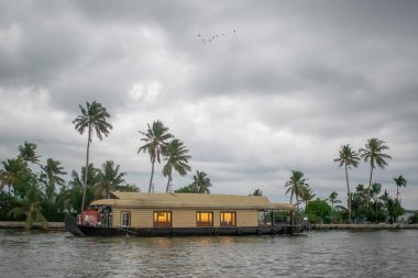 Akşamları Alappuzha Alleppey Kerala 'da lüks bir otelin önünde tekneler yüzüyor.