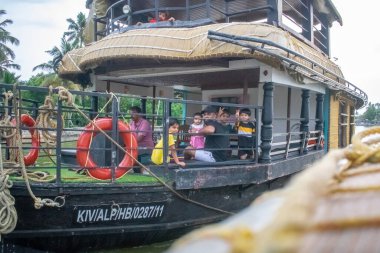 a tourist family is enjoying their trip of houseboat in backwater of Alappuzha Alleppey Kerala clipart