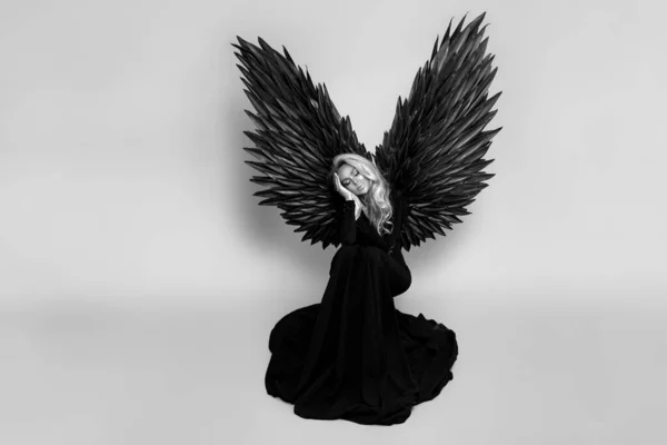 Prachtige Blonde Vrouw Elegante Lange Zwarte Jurk Grote Vleugels Poseert — Stockfoto