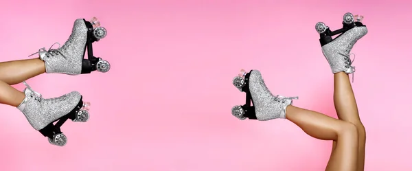 女性の体の部分の写真を閉じます 足を身に着けている魅力的なシルバーの輝きローラースケートで靴紐でピンク鮮やかな背景 — ストック写真